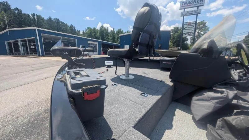 Slide: The Image of 2022 Tracker Pro Guide V 16 SC boat interior with seating and storage, dealership background. - 5