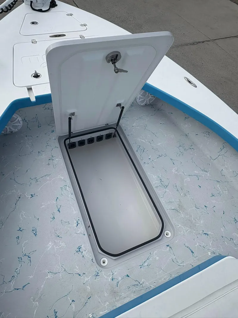 Slide: The Image of Open storage compartment on 2022 Mamba 24VX boat with marbled flooring. - 11