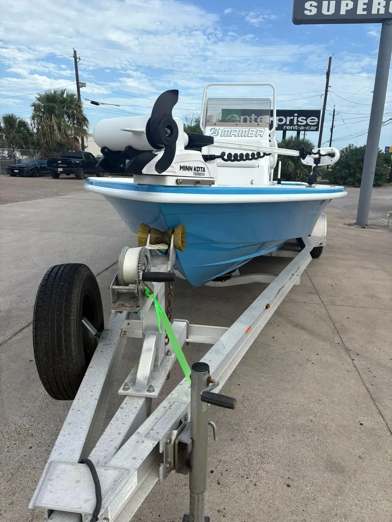 Slide: The Image of 2022 Mamba 24VX boat on trailer with Minn Kota motor, parked outdoors. - 13