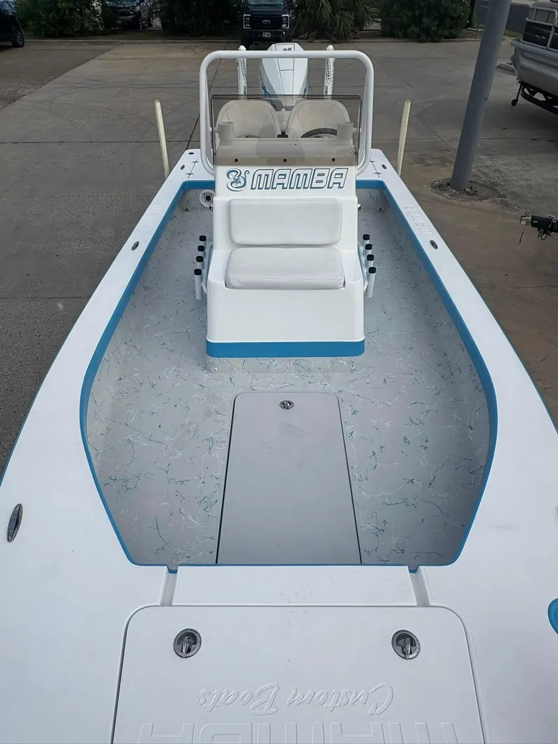 Slide: The Image of 2022 Mamba 24VX boat with white and blue interior, docked on concrete. - 15