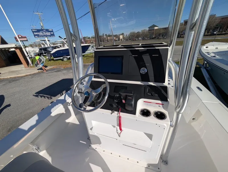 Slide: The Image of 2025 Bay Rider 239 Bay boat console with steering wheel and controls, parked at Angler's Marine. - 6