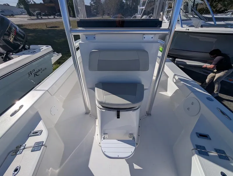 Slide: The Image of 2025 Bay Rider 239 Bay boat interior with seating and console, displayed outdoors. - 9
