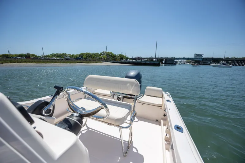 Slide: The Image of 2010 Grady-White Sportsman 180 boat on calm water near a bridge. - 11