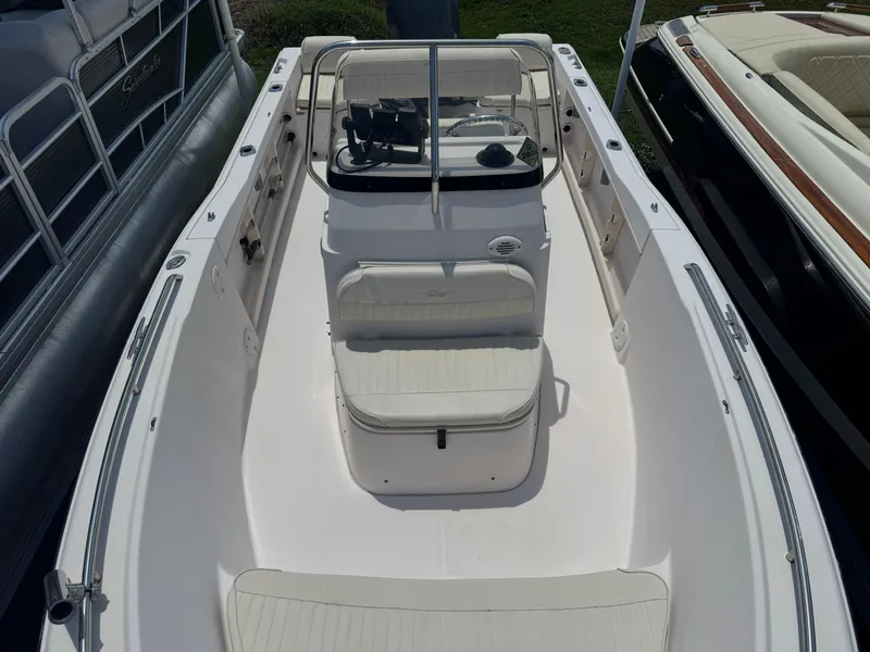 Slide: The Image of 2010 Grady-White 180 Sportsman boat interior with seating and console, docked between other boats. - 6
