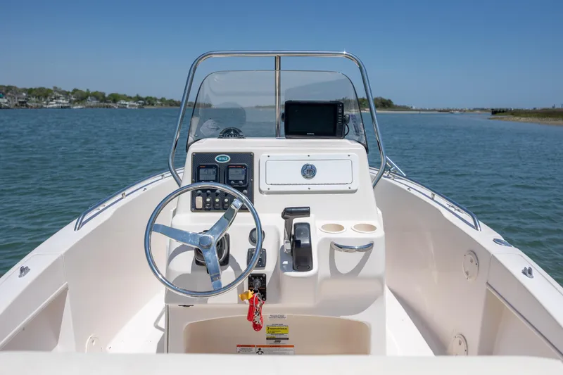 Slide: The Image of 2010 Grady-White Sportsman 180 boat dashboard with steering wheel and controls on open water. - 8