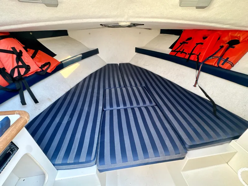 Slide: The Image of Interior cabin of 2001 Pursuit 2460 Denali boat with striped cushions and life jackets. - 10