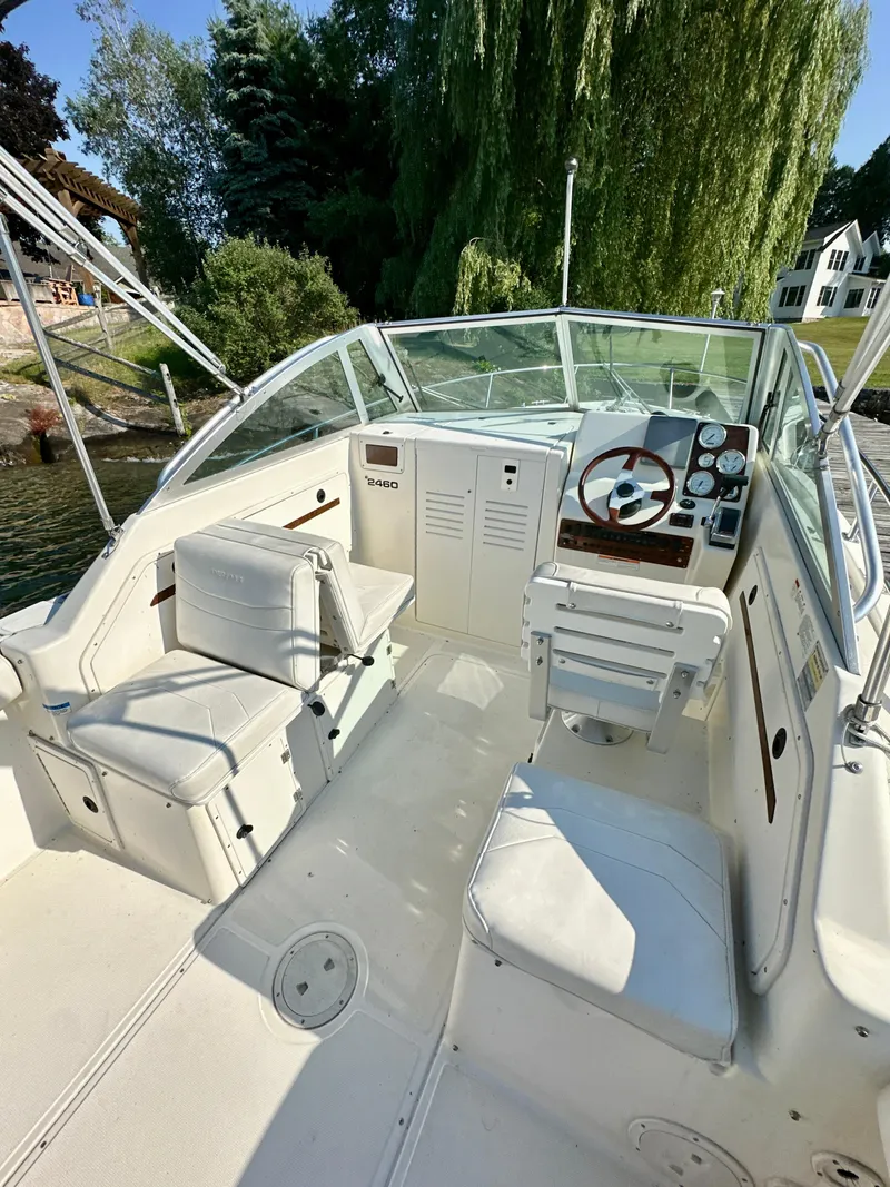Slide: The Image of 2001 Pursuit 2460 Denali boat interior with white seating and control panel. - 5