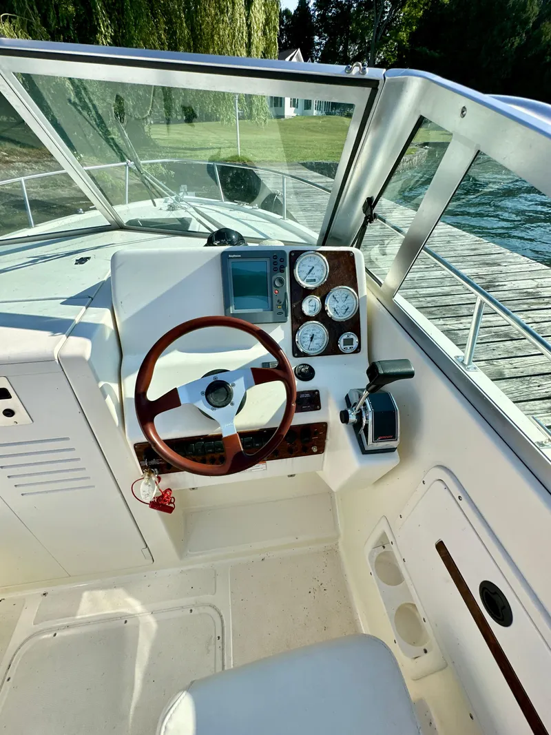 Slide: The Image of 2001 Pursuit 2460 Denali boat cockpit with steering wheel and instrument panel. - 9
