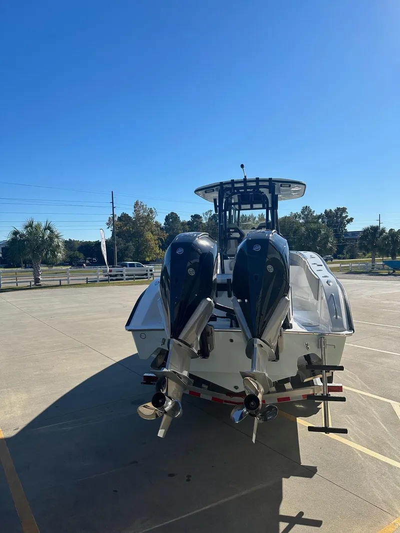 Slide: The Image of 2025 Cape Horn 28XS boat with dual outboard engines in a sunny parking lot. - 6
