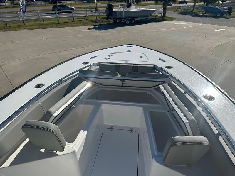 Slide: The Image of 2025 Cape Horn 28XS boat interior with seating and storage, parked outdoors. - 18