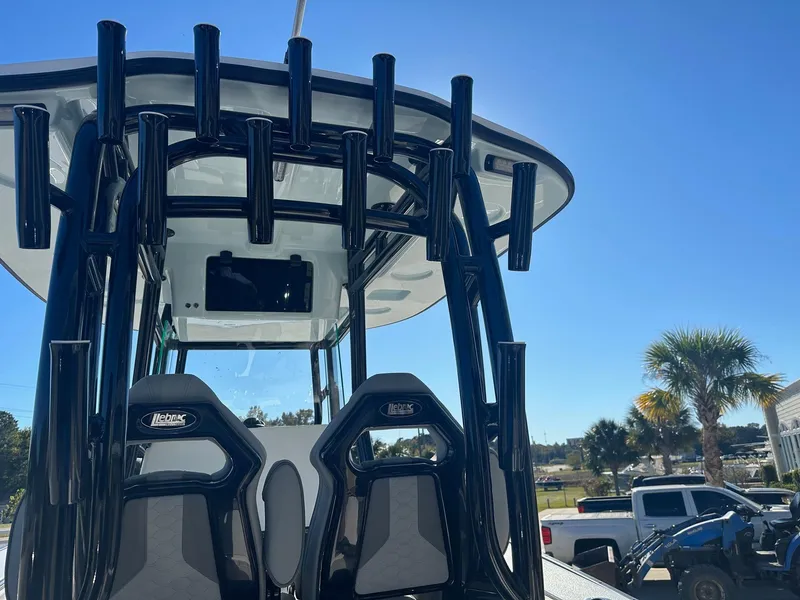 Slide: The Image of 2025 Cape Horn 28XS boat with rod holders and seating, under clear blue sky. - 15