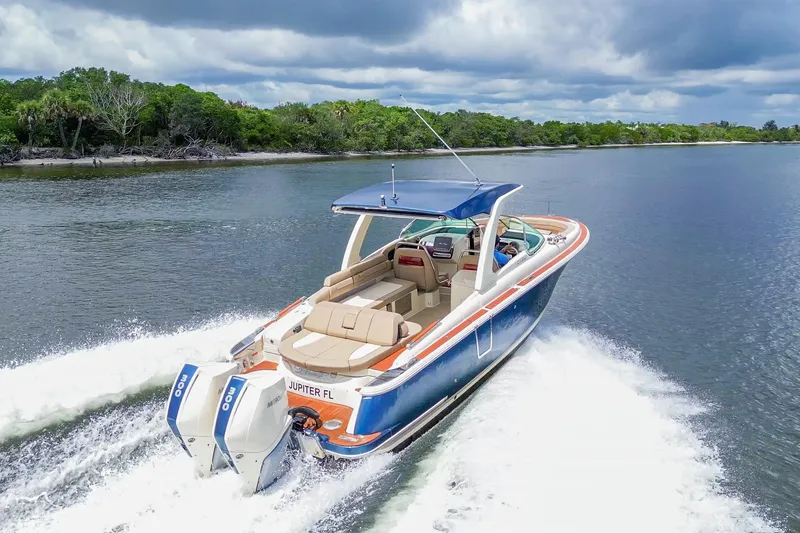 Slide: The Image of 2023 Chris-Craft Launch 31 GT cruising on a scenic waterway under cloudy skies. - 3