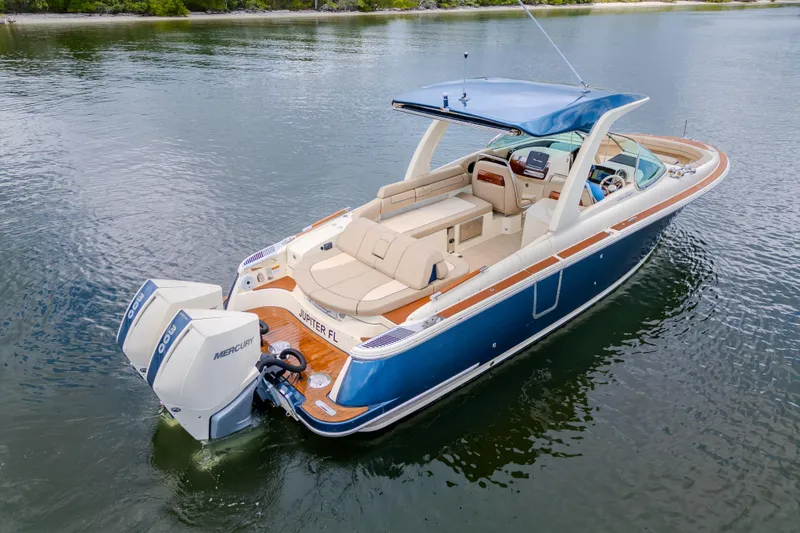 Slide: The Image of 2023 Chris-Craft Launch 31 GT boat on calm water, featuring dual Mercury engines. - 8