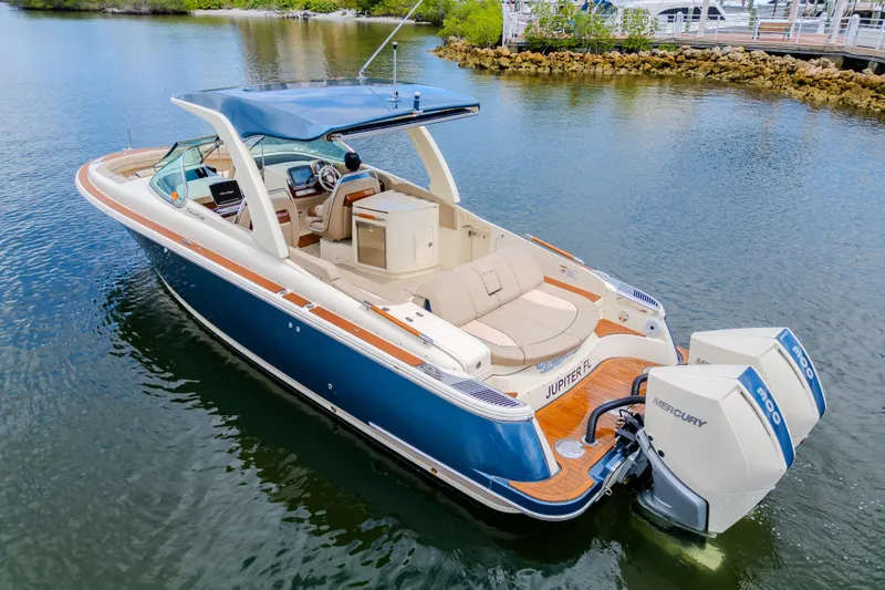 Slide: The Image of 2023 Chris-Craft Launch 31 GT boat with dual Mercury engines on calm water. - 9