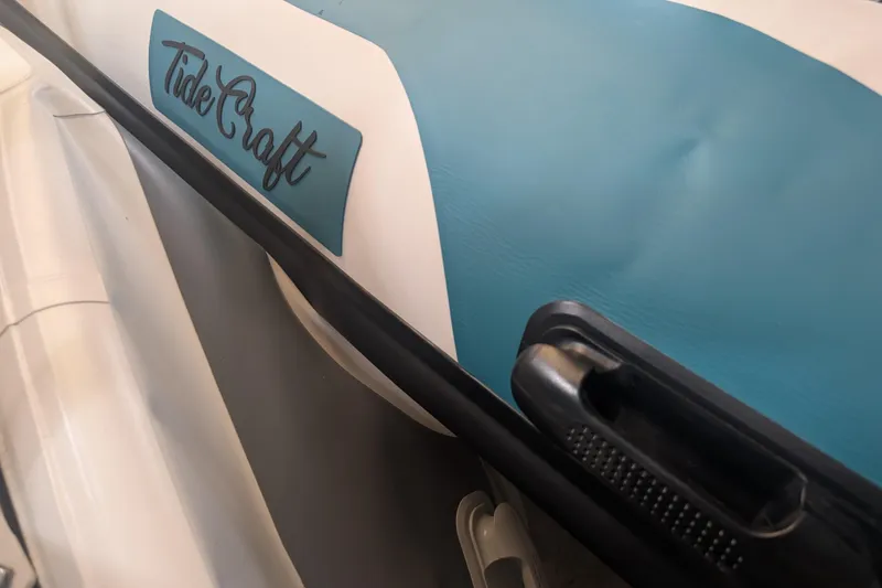 Slide: The Image of Tide Craft Custom Teal, Black, and White Nantucket 12 boat, 2025 model, close-up view. - 4