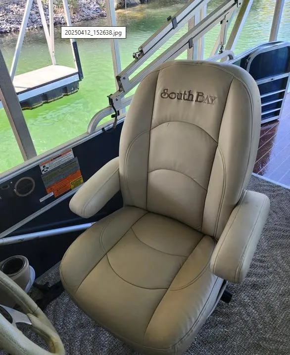 Slide: The Image of Captain's chair on 2013 South Bay 522CR TT pontoon boat, overlooking green water. - 12