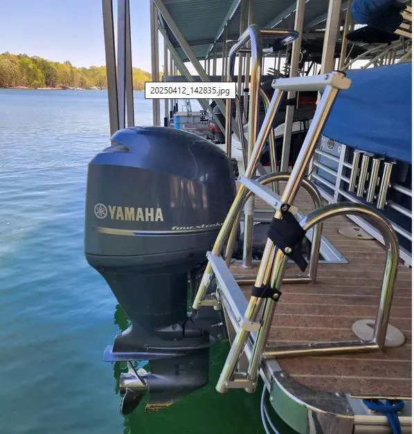 Slide: The Image of Pontoon boat with Yamaha outboard motor and ladder, docked on a calm lake. - 13