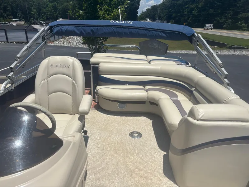 Slide: The Image of 2013 South Bay 522CR TT pontoon boat with beige seating and blue canopy. - 2