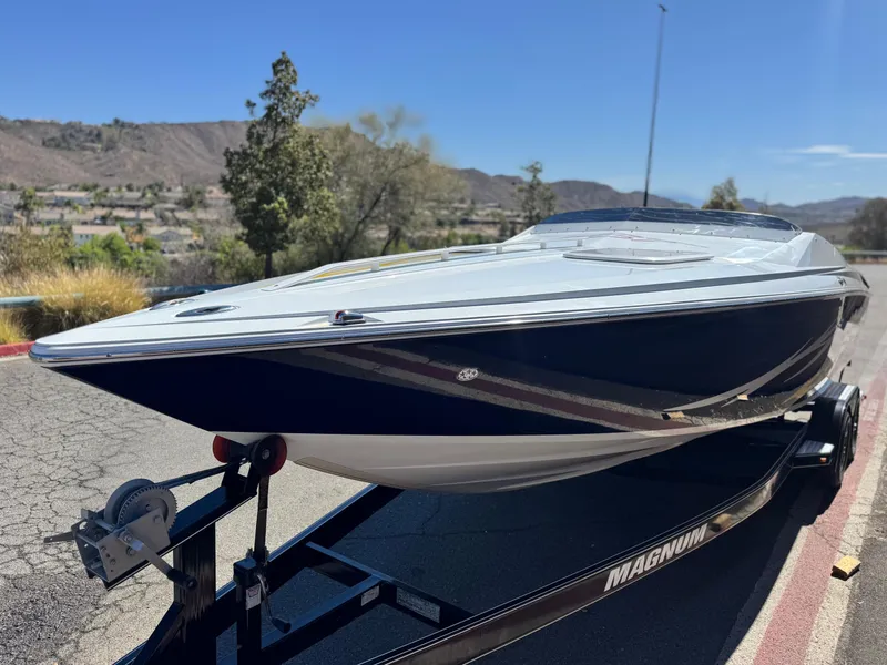 Slide: The Image of 2007 Baja 26 Outlaw boat on trailer, parked outdoors under clear sky. - 3