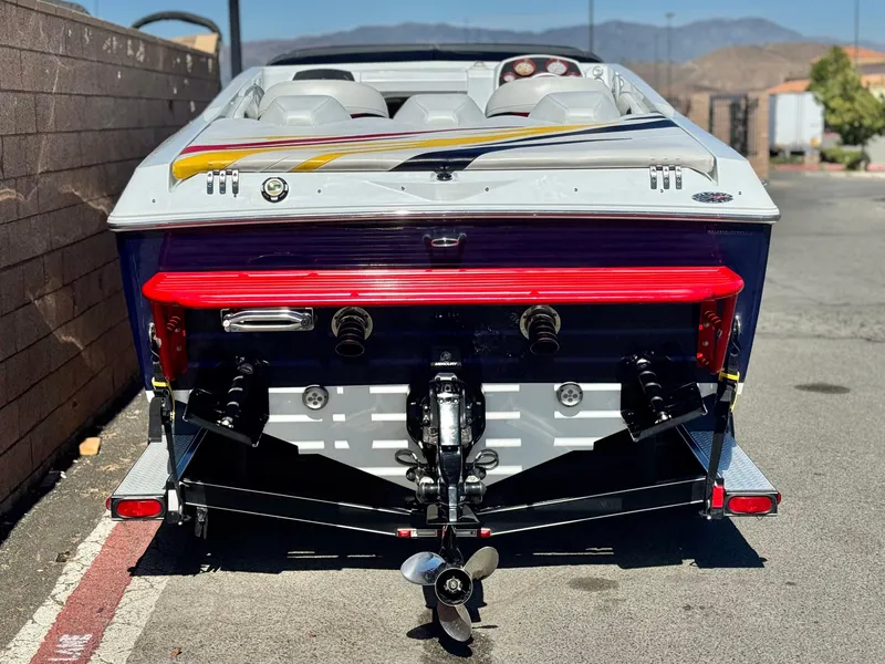 Slide: The Image of 2007 Baja 26 Outlaw boat rear view, showcasing dual engines and vibrant red accents. - 4