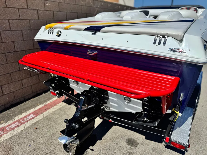 Slide: The Image of 2007 Baja 26 Outlaw boat with vibrant red swim platform and sleek design. - 6