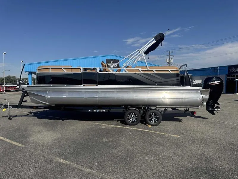 The Image of 2025 Avalon 2385 25 Venture QL pontoon boat on trailer, parked outdoors. - 1