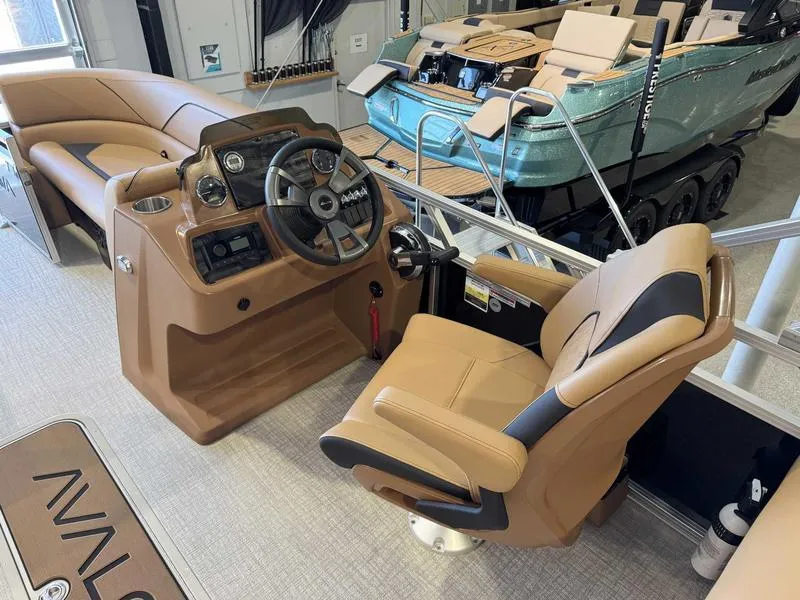Slide: The Image of Interior of 2025 Avalon 2385 25 Venture QL boat with luxurious seating and steering console. - 10