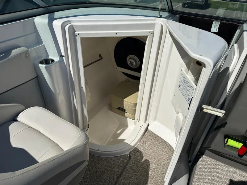 Slide: The Image of 2014 Rinker Captiva 246 BR boat interior with open storage compartment and seating. - 13