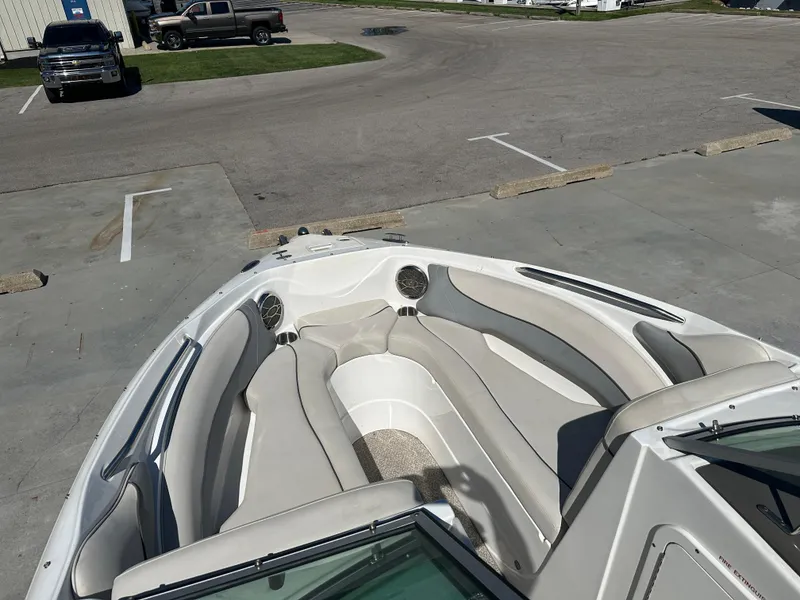 Slide: The Image of 2014 Rinker Captiva 246 BR boat with spacious seating in a parking lot. - 14