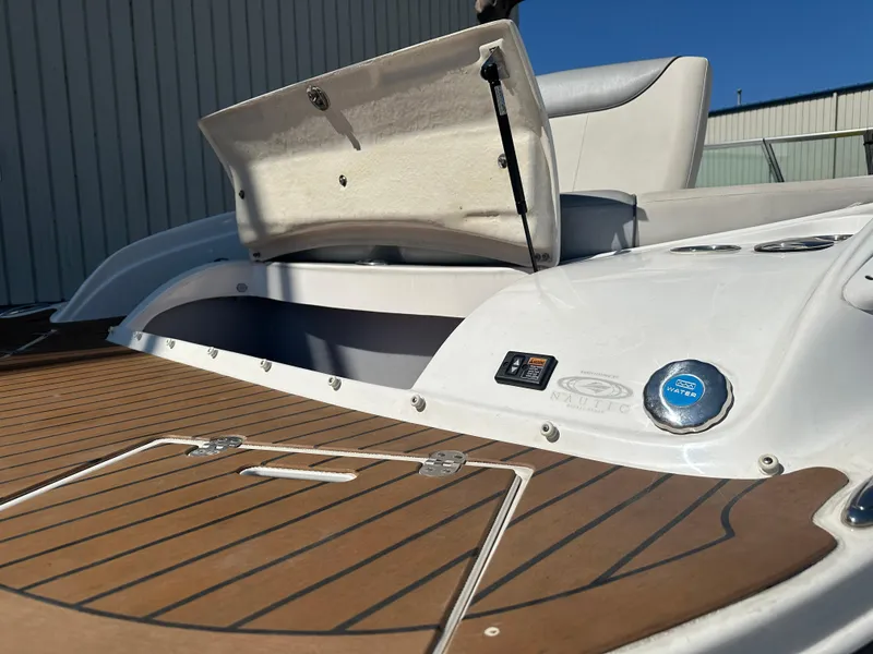 Slide: The Image of 2014 Rinker Captiva 246 BR boat with open storage compartment and teak deck. - 19