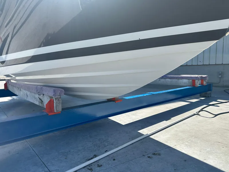 Slide: The Image of 2014 Rinker Captiva 246 BR boat hull on a blue trailer in sunlight. - 2