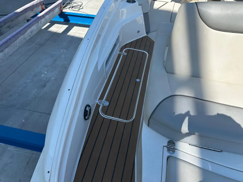 Slide: The Image of 2014 Rinker Captiva 246 BR boat interior with cushioned seating and wood-style flooring. - 22