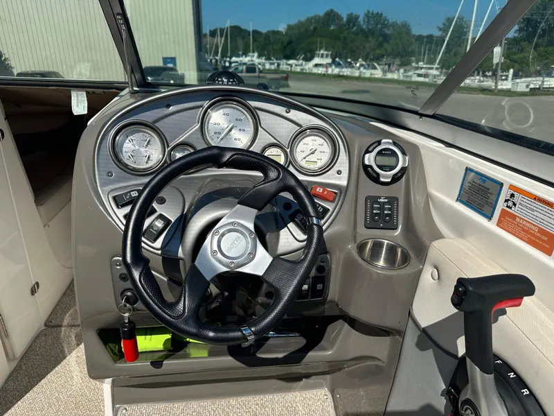 Slide: The Image of 2014 Rinker Captiva 246 BR boat dashboard with steering wheel and gauges. - 8