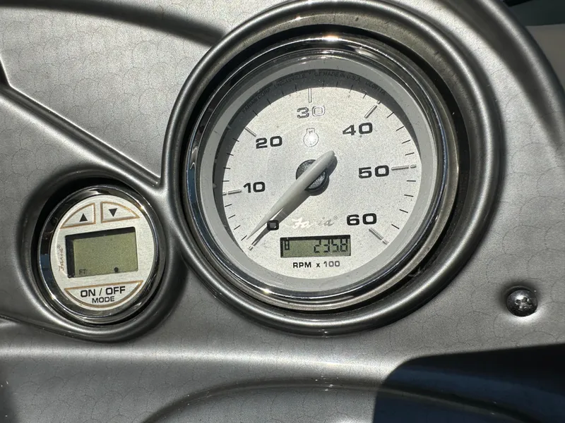 Slide: The Image of Dashboard of 2014 Rinker Captiva 246 BR showing RPM gauge and digital display. - 9