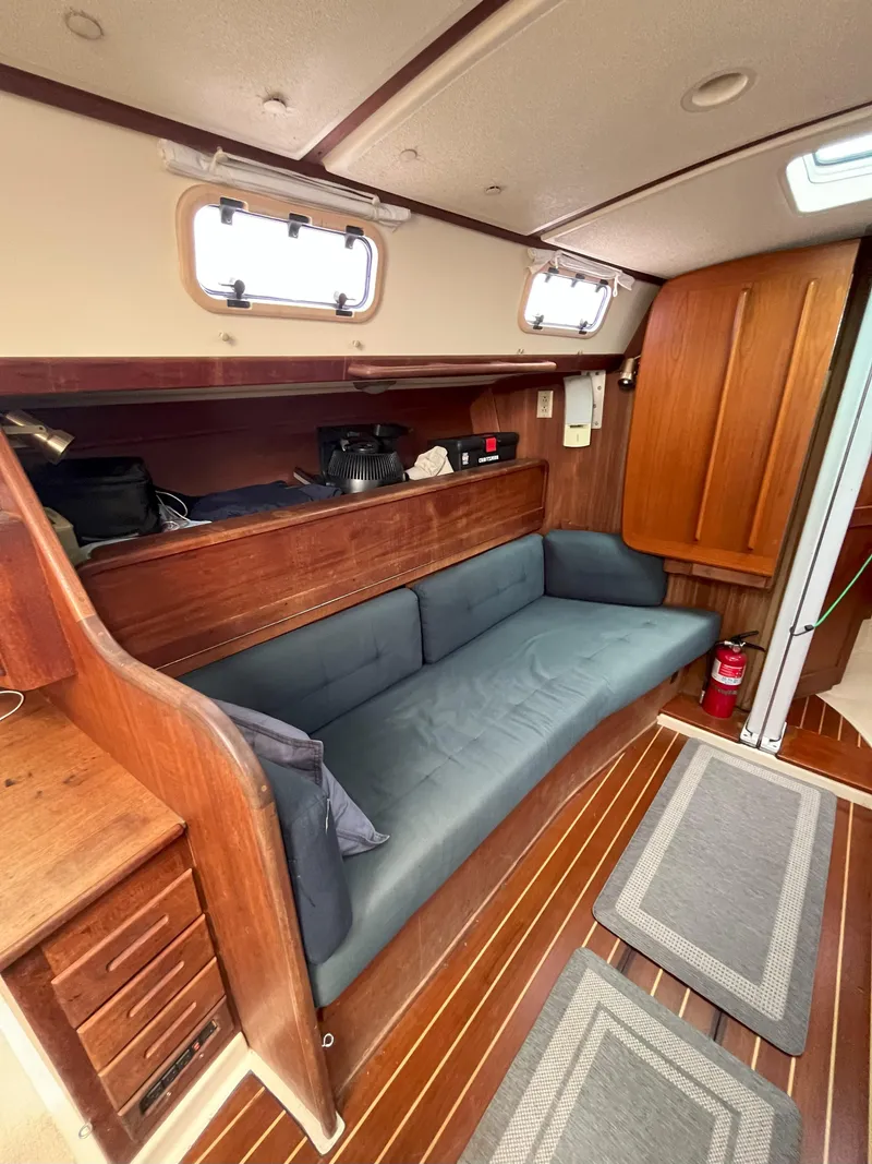 Slide: The Image of Interior of 1988 Tartan 31 sailboat with wooden finish and blue seating. - 12