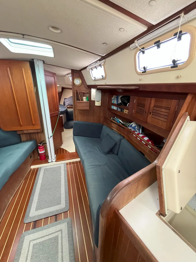 Slide: The Image of Interior of a 1988 Tartan 31 sailboat with wooden furnishings and cozy seating. - 13