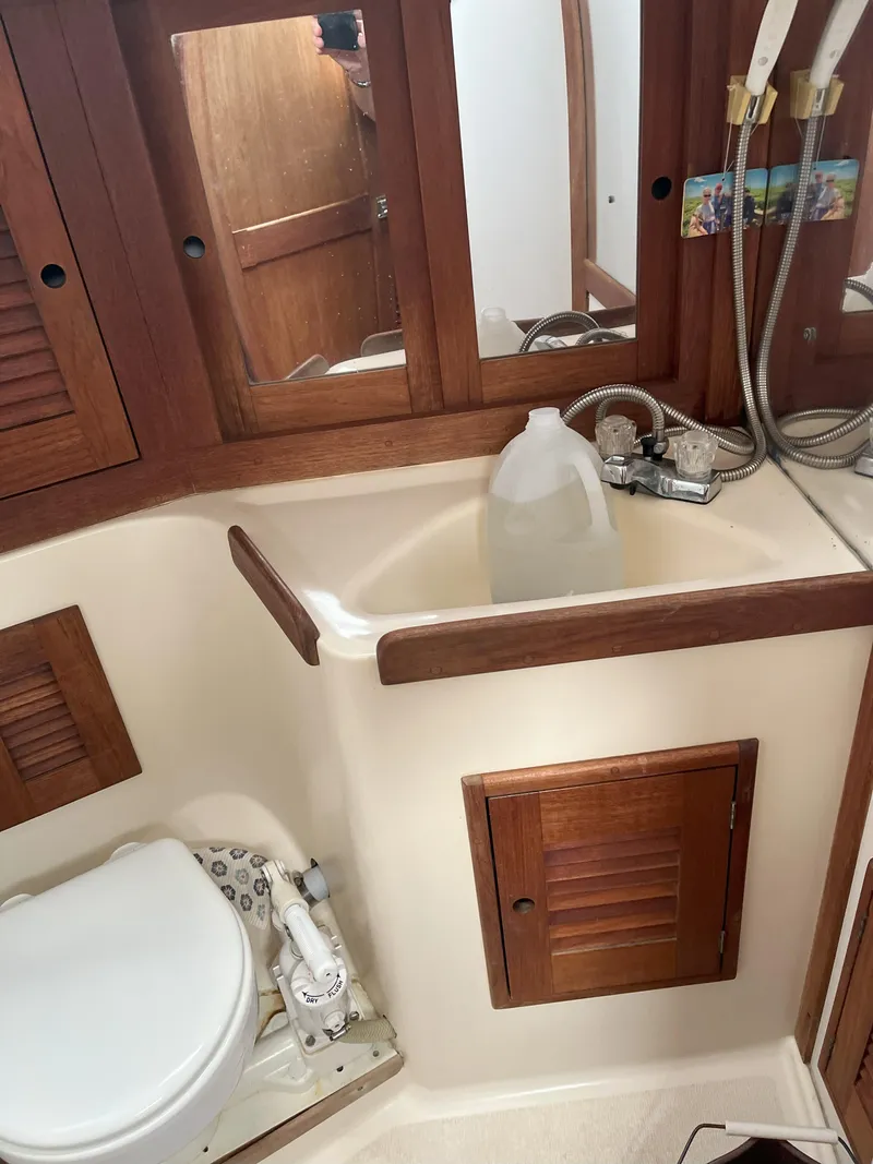 Slide: The Image of Bathroom interior of a 1988 Tartan 31 sailboat with wooden cabinets and sink. - 15