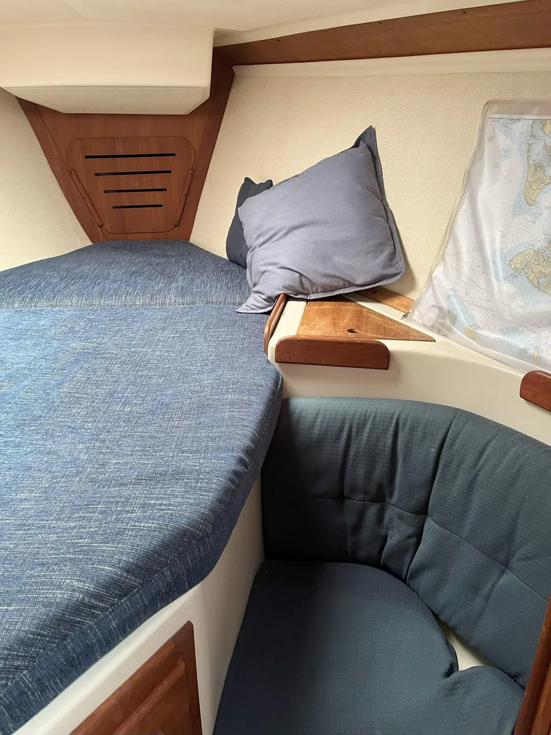 Slide: The Image of Cozy cabin interior of 1988 Tartan 31 sailboat with blue cushions and wooden accents. - 19