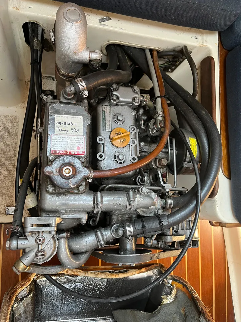 Slide: The Image of Engine compartment of a 1988 Tartan 31 sailboat, showcasing mechanical components and hoses. - 23