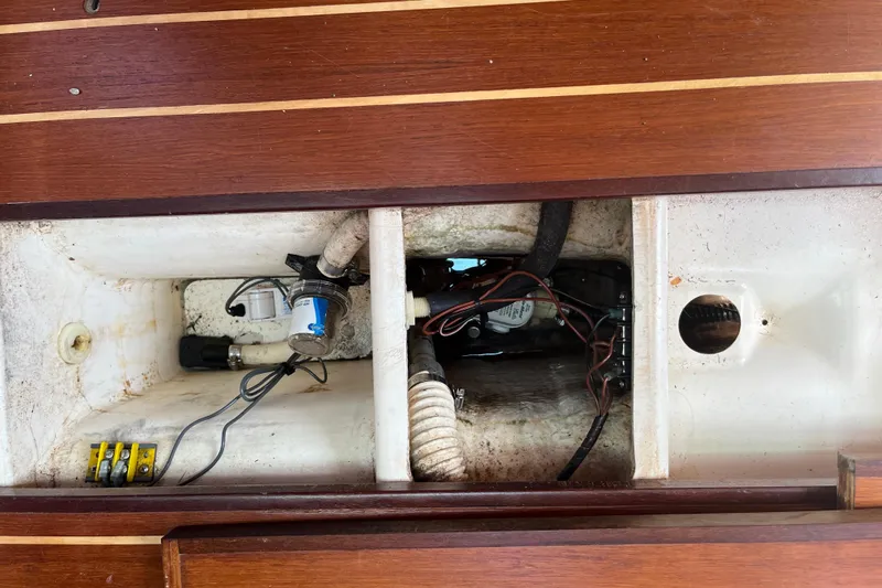 Slide: The Image of Bilge area of a 1988 Tartan 31 sailboat with visible wiring and pump components. - 26