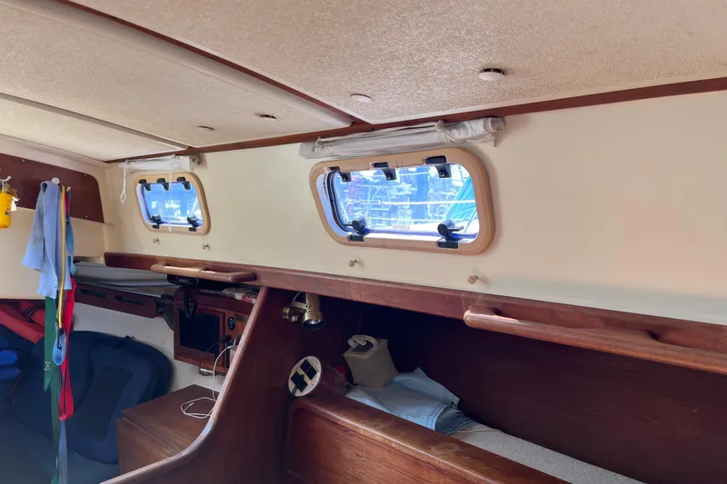 Slide: The Image of Interior of a 1988 Tartan 31 sailboat, featuring wooden accents and porthole windows. - 29