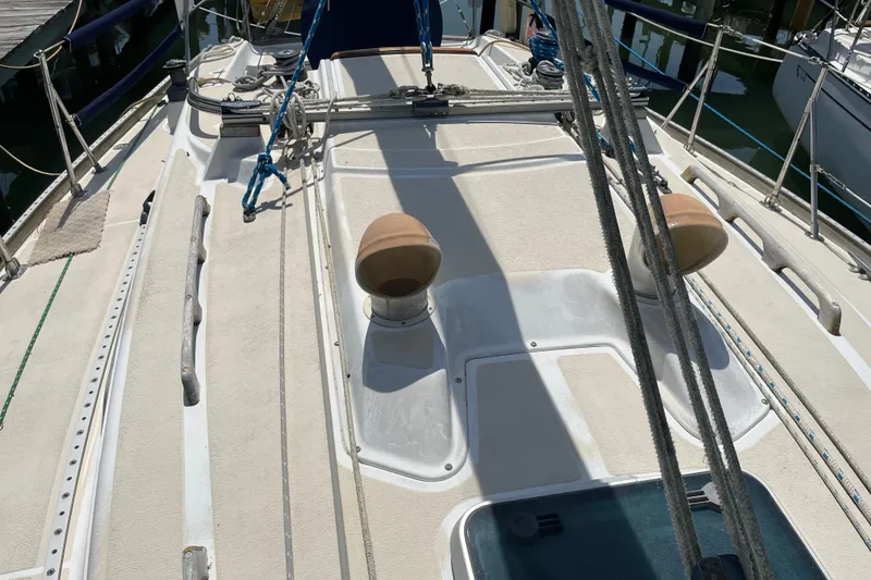 Slide: The Image of 1988 Tartan 31 sailboat deck with winches and rigging in a marina setting. - 39