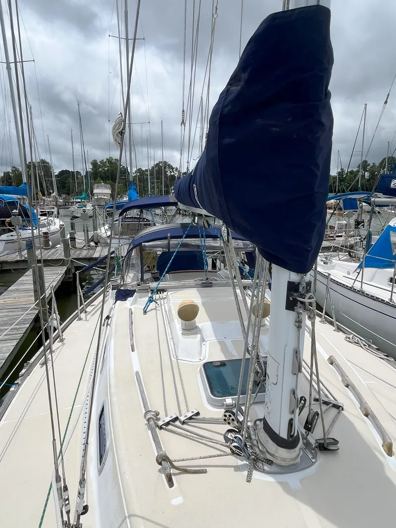 Slide: The Image of 1988 Tartan 31 sailboat docked, featuring blue sail cover and rigging. - 4