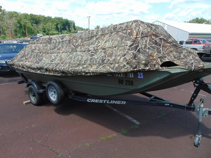 Slide: The Image of 2016 Crestliner 1860 Retriever Jon Deluxe boat with camouflage cover on a trailer. - 14