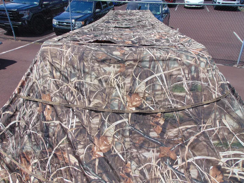 Slide: The Image of 2016 Crestliner 1860 Retriever Jon Deluxe with camouflage cover in a parking lot. - 15