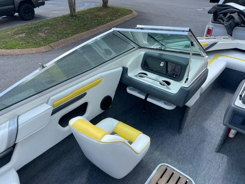 Slide: The Image of 1990 Sea Ray 180 Bow Rider interior with yellow and white seating, parked in a lot. - 3