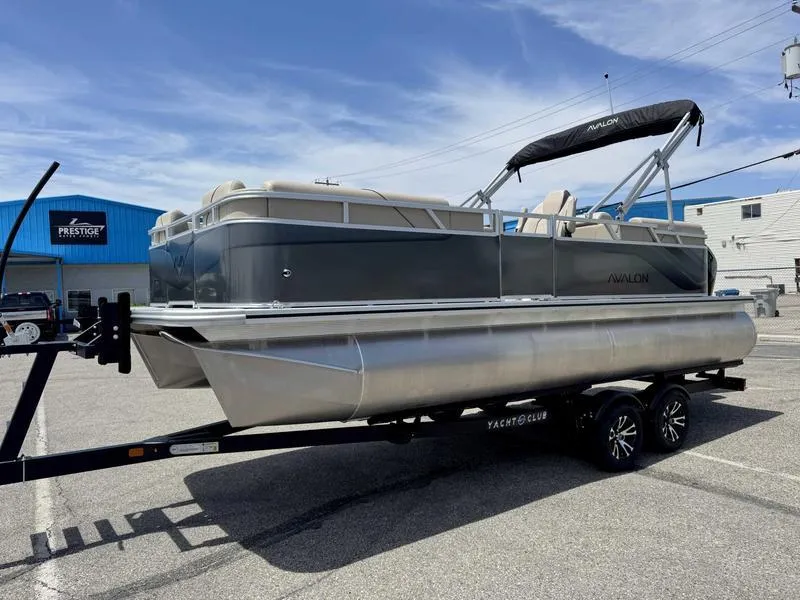 Slide: The Image of 2025 Avalon 2180 23 Venture QL pontoon boat on trailer, parked outdoors. - 1