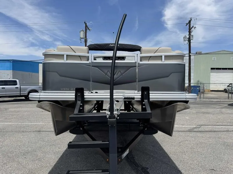 Slide: The Image of 2025 Avalon 2180 23 Venture QL pontoon boat on trailer, parked in industrial area. - 3