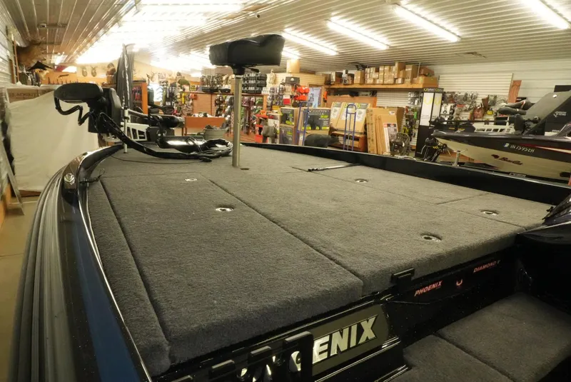 Slide: The Image of 2026 Phoenix 921 Elite X boat interior with carpeted deck in showroom. - 18