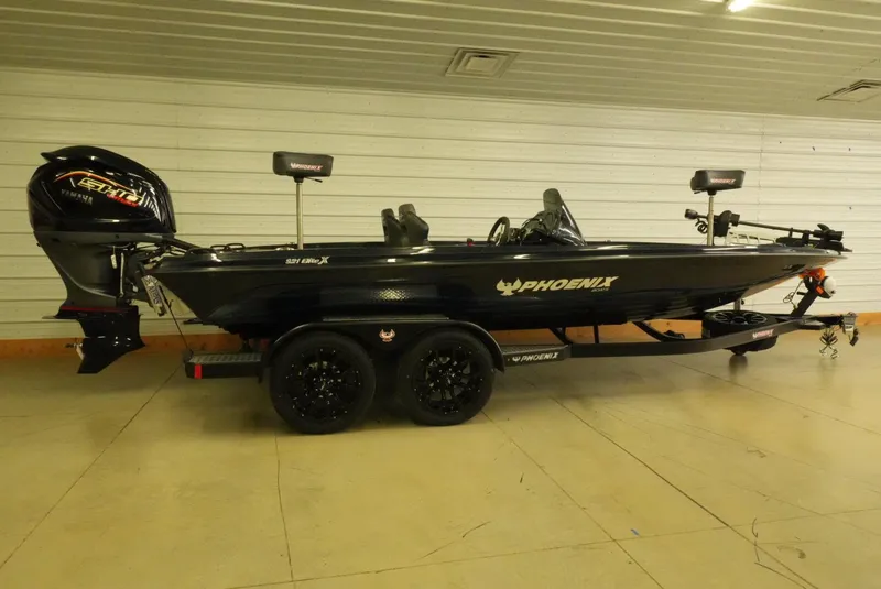 Slide: The Image of 2026 Phoenix 921 Elite X boat in a garage, featuring a sleek black design. - 2